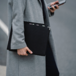 zoom sur une femme entrain de marcher avec dossiers et téléphone dans les mains